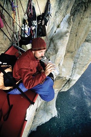 a climber sits on his ledge on a big wall