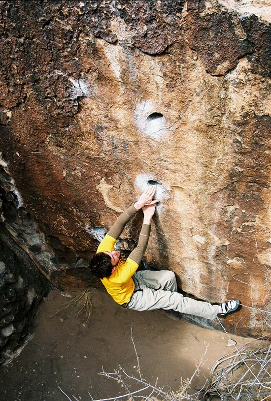 Andy Mann warming-up a must-do line near the Mushroom Boulder in Hueco: Orifice Affair. [v1] © Photo by Justin Jaeger