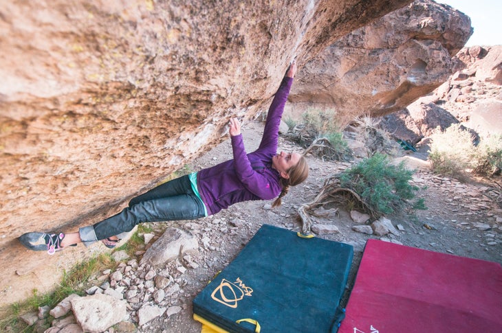 Climber in purple shirt demonstrates Side Flag climbing technique.