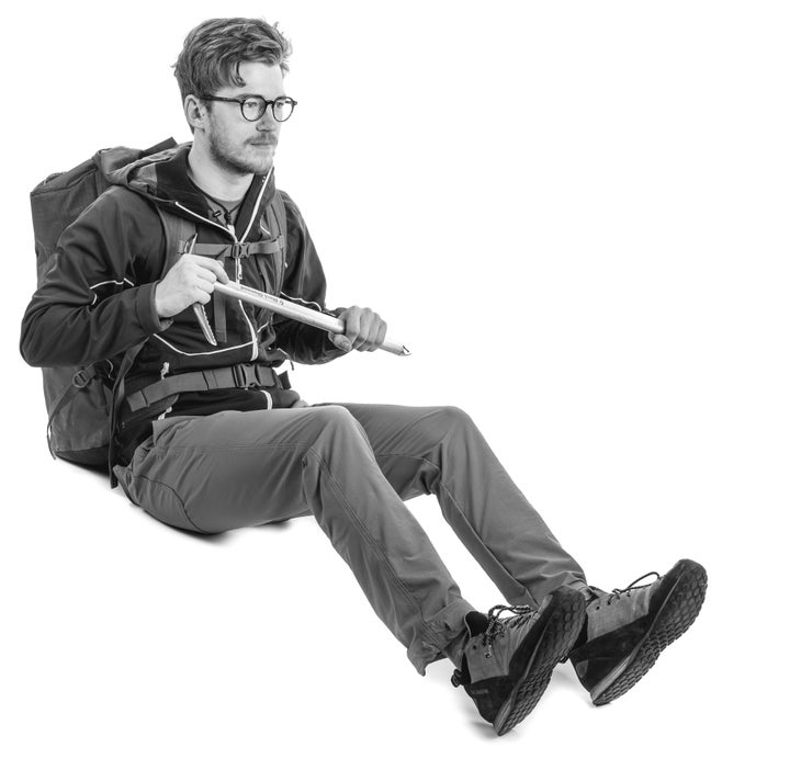 A mountaineer sliding or glissading down a snow covered mountain