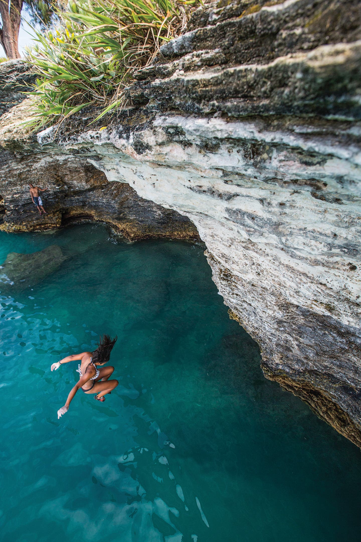 a woman falling safely while deep-water soloing