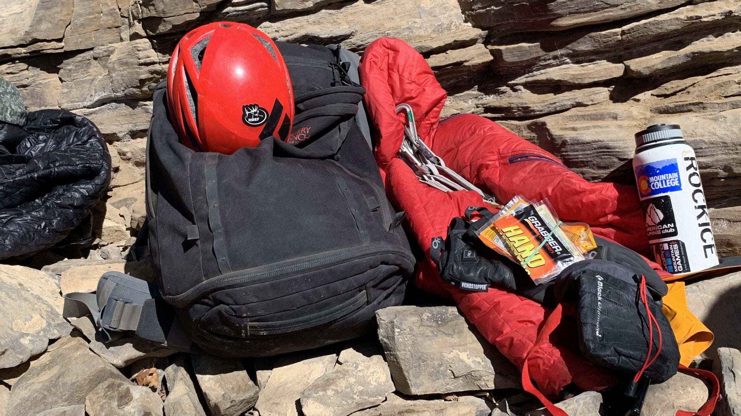 Cold-weather-climbing essentials kit. From left: puffy jacket (duh!), heated gloves, chemical handwarmers, Hot Forge Heated Chalk Bag, insulated water bottle with a hot drink.