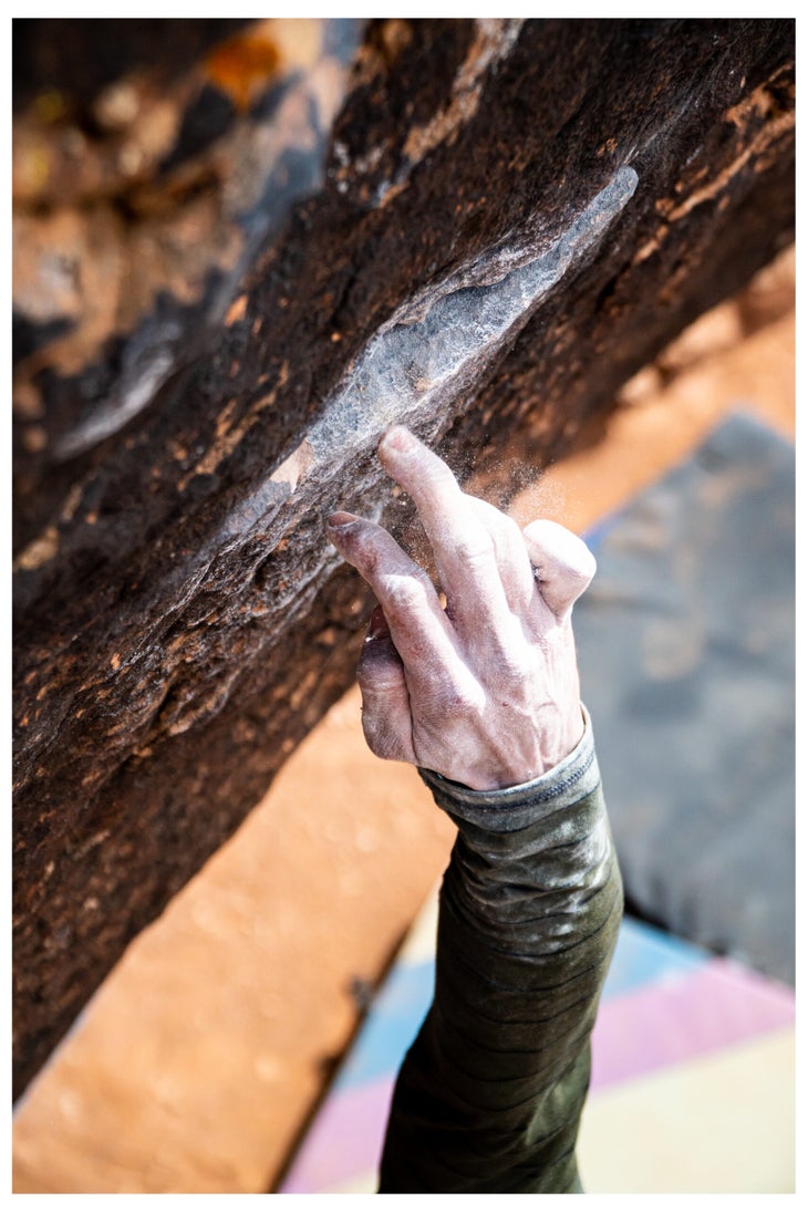 A climber's hand dry firing off an edge.