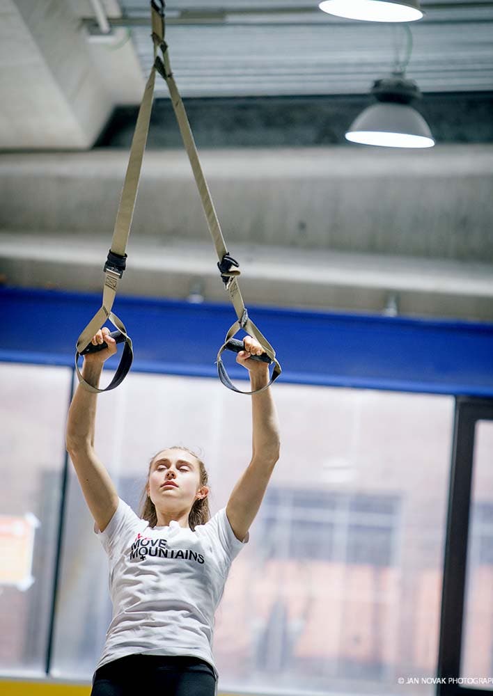 Climber Margo hayes using TRX bands in a gym.