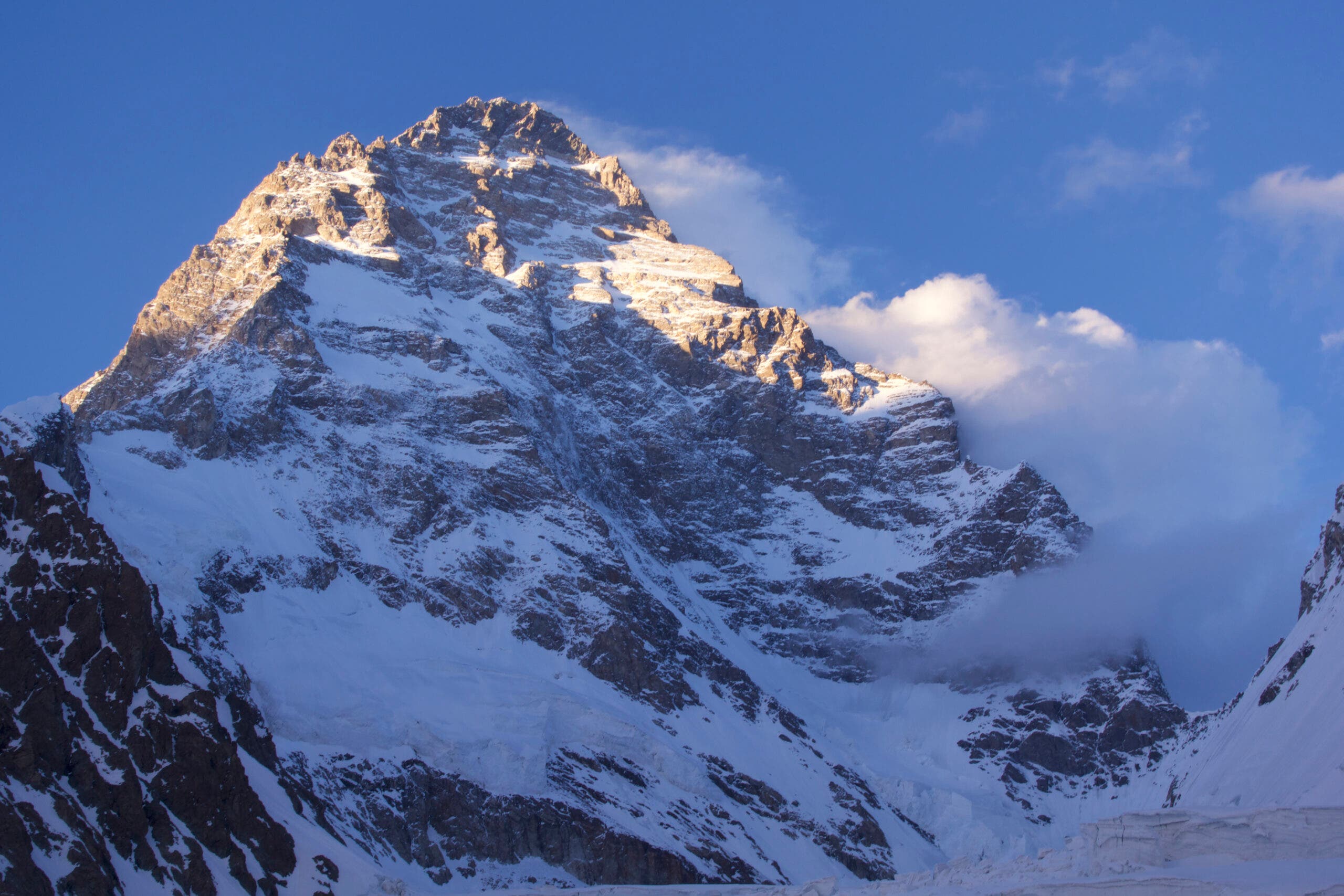 The South Face of K2. The upper 1/4 of the mountain is in sun. The lower slopes are in cold blue shadow.