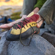 Close up of a climber tying shoelaces of his climbing shoes
