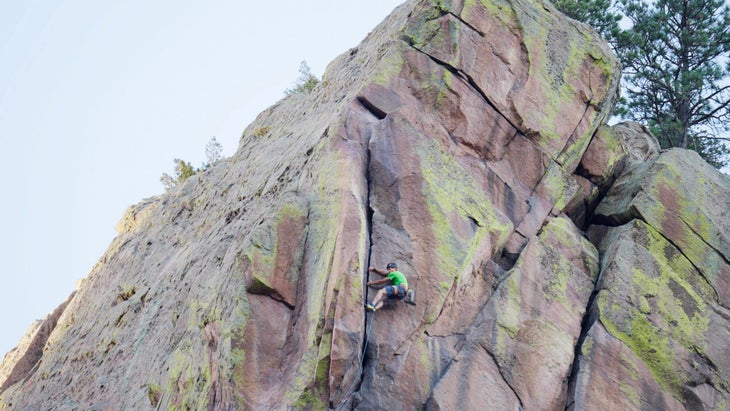 Rock climber on last section of Naked Edge rock climb in Eldorado Springs Canyon, Colorado.