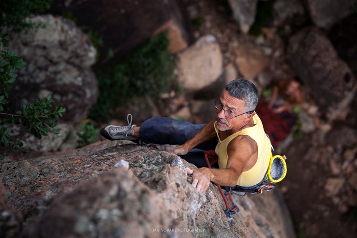An older climber on a vertical moderate, where low-intensity endurance helps.