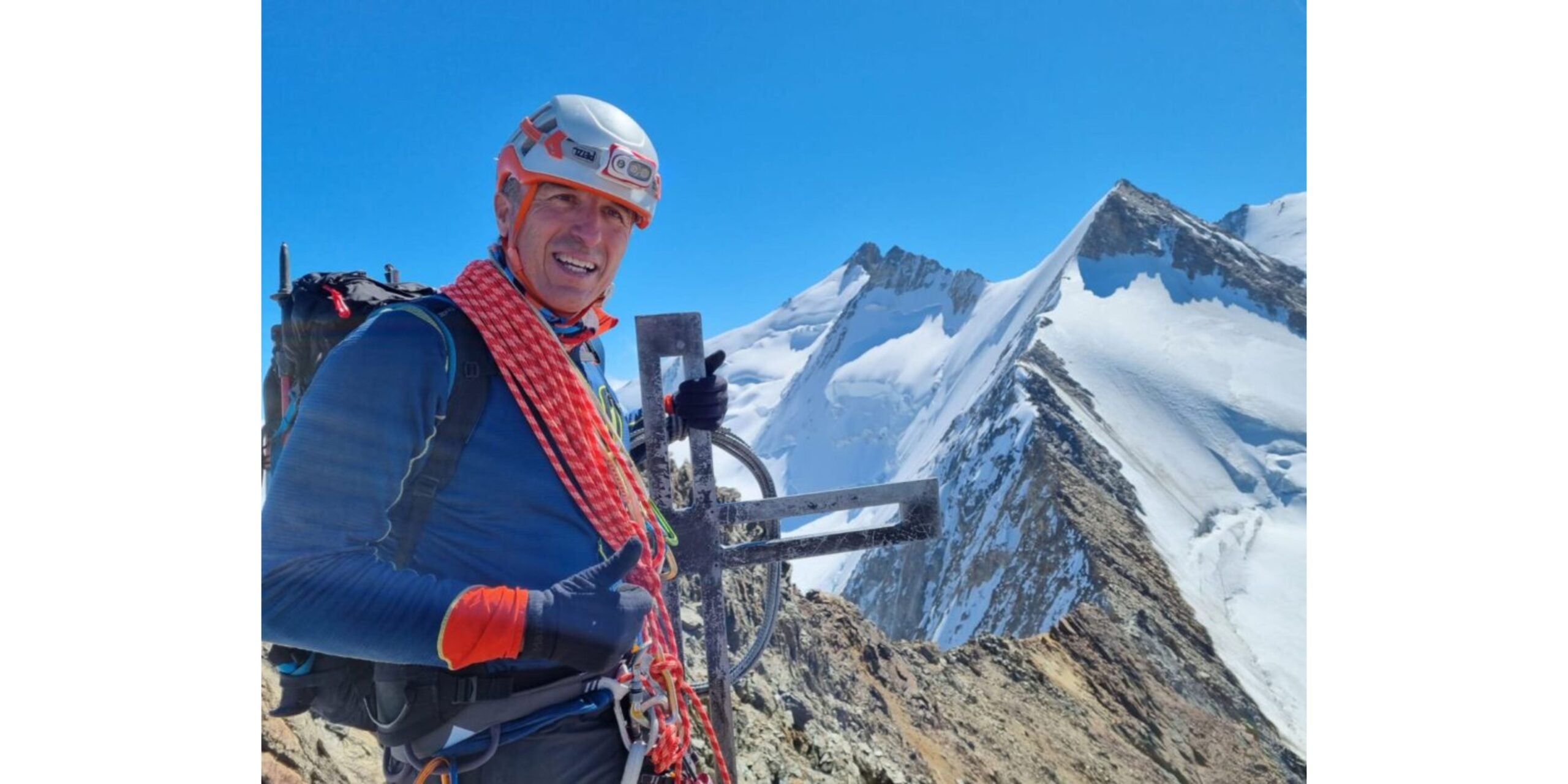 Antonios Sykaris stands on summit after alpine climb in the Alps.