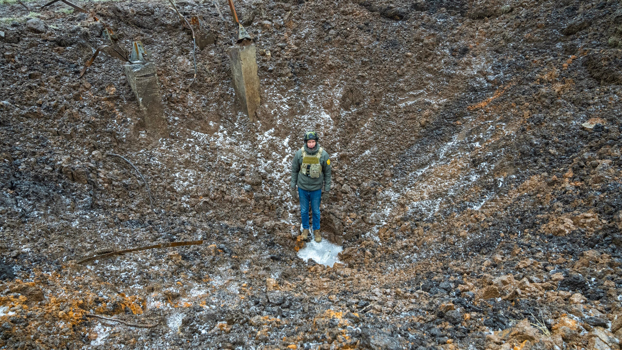 Mykhailo "Misha" Poddubnov, founder of Climb Army, standing in a S300 missile crater in Kharkiv Oblast, Ukraine, in December 2022.