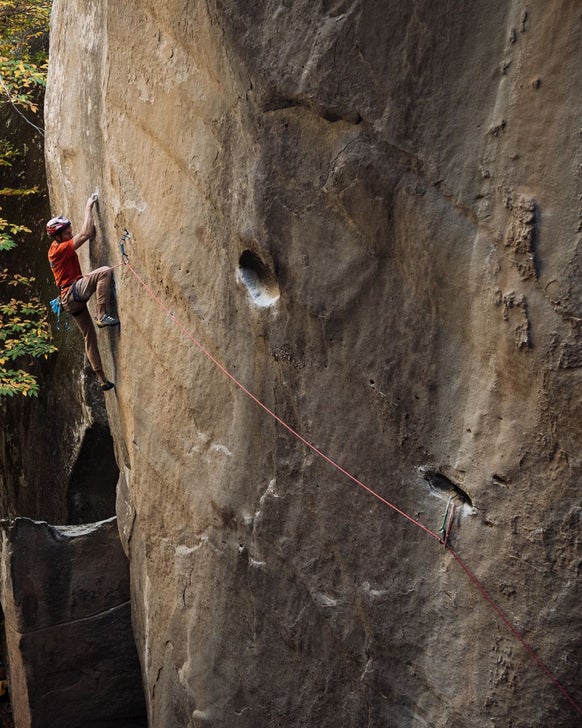 James Pearson climbs a vertical rock wall.