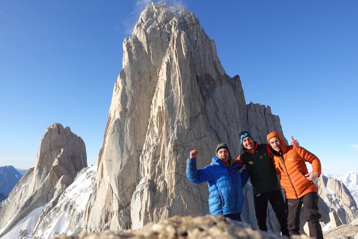 Tres escaladores en la cumbre de la Aguja Mermoz, frente al Fitz Roy, en la Patagonia.