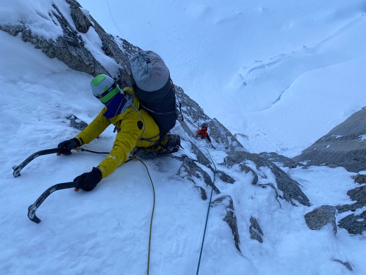 Two ice climbers top rope a mixed pitch on Mt. Huntington, AK.