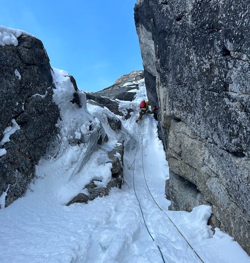 Mixed climber stems up a vertical granite pitch on Mt. Huntington, AK.