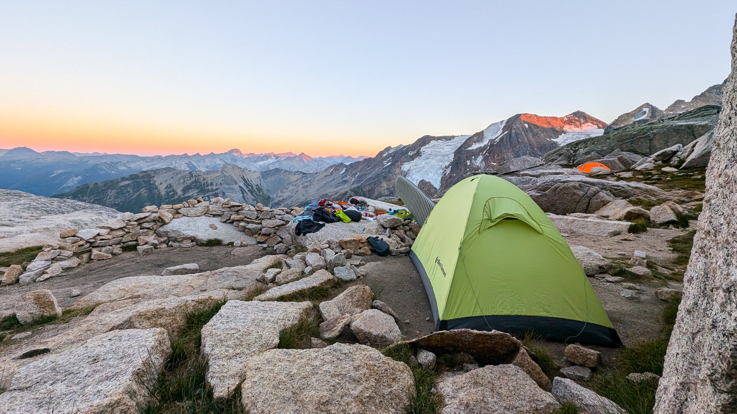 A climber's tent set up at sunset in an alpine boulderfield. The tent and sleeping pad in this image is of the best camping gear for climbers.