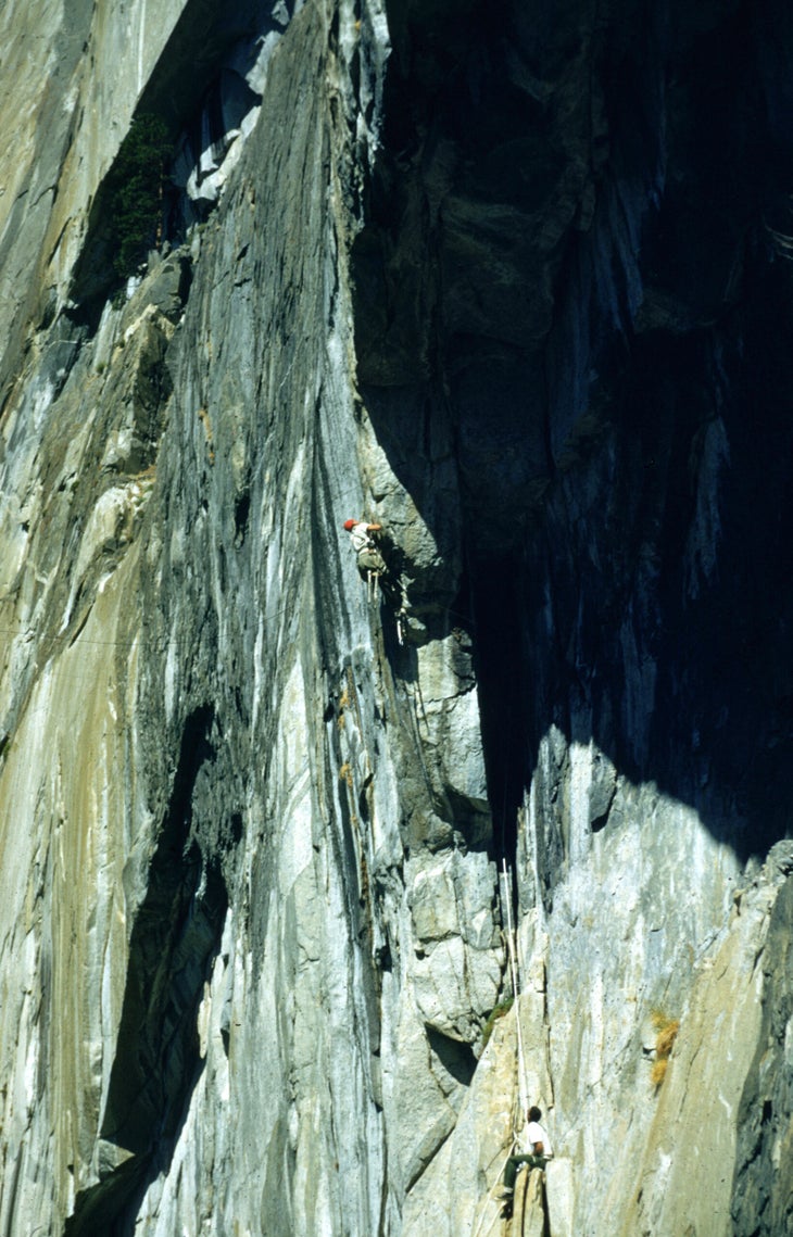 Man aid climbs vertical crack in Yosemite.