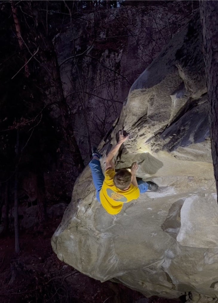 Martin Keller, climbing at night, wearing blue pants and a yellow t-shirt. The photo does a good job of showing how steep Gateway is.
