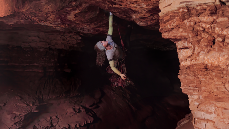 Mary Eden climbing on Black Mamba with several #7 cams dangling from her harness.