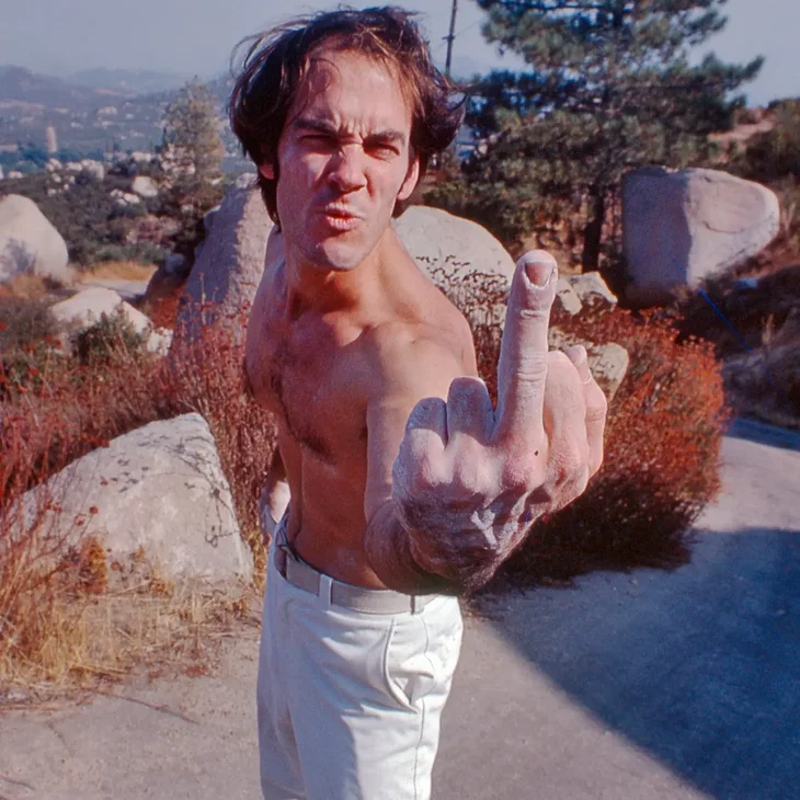 Dick Shockley giving the bird to the camera at a bouldering area in the 1070s