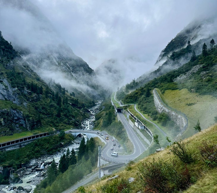 A curving highway as viewed from the base of Wädlichlimser, a rock climb in the alps.