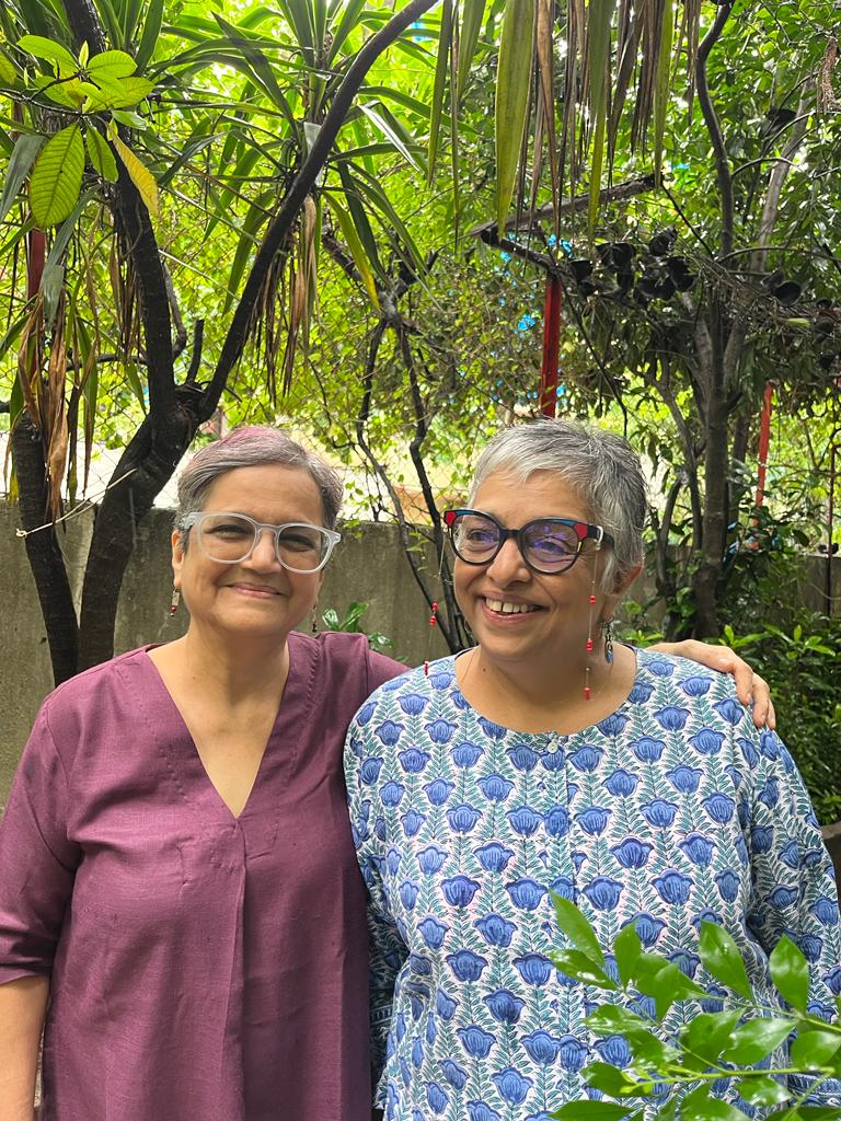 The authors, Nandine Purandare and Deepa Balsavar, standing side by side among green trees