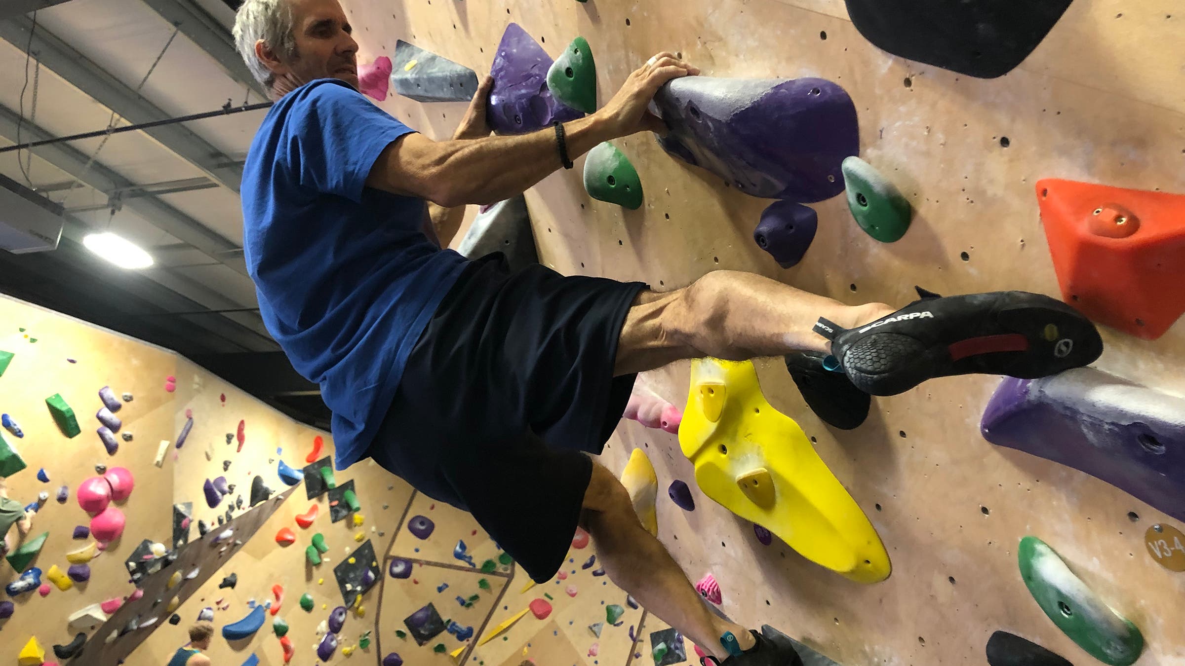 Matt Samet testing shoes on a gym rock wall