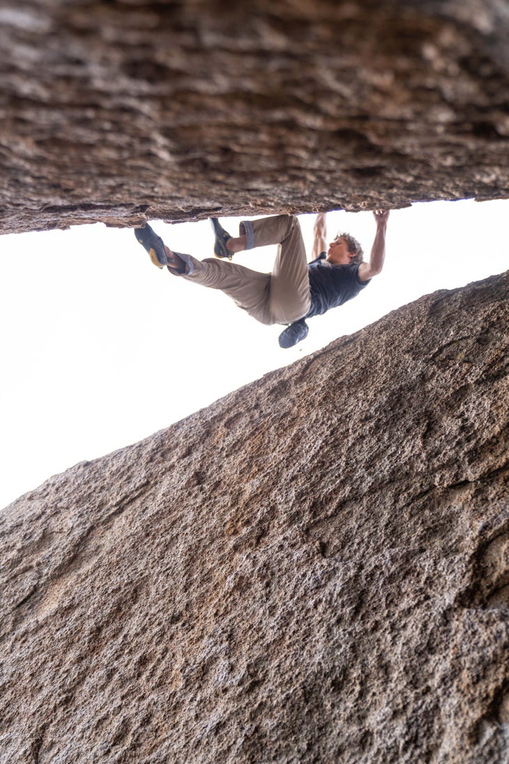 A climber on a tall V9 with a bad landing.