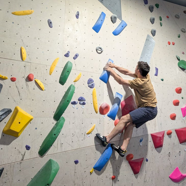 Man climbs vertical climbing gym walll wearing La Sportiva Mandala shoe.