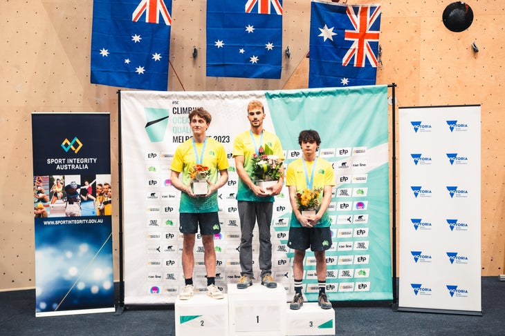 Olympic climber Campbell Harrison stands on podium after climbing competition.