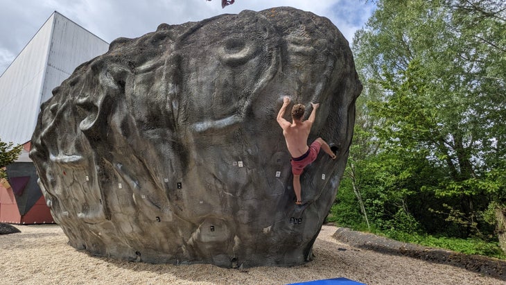 A man climbing on a cement boulder at Klimcentrum Bjoeks