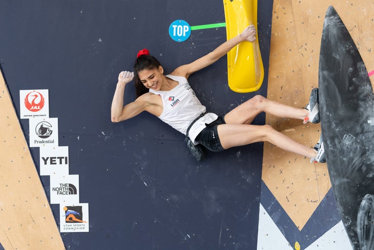 Natalia Grossman celebrating at the top of a competition boulder.
