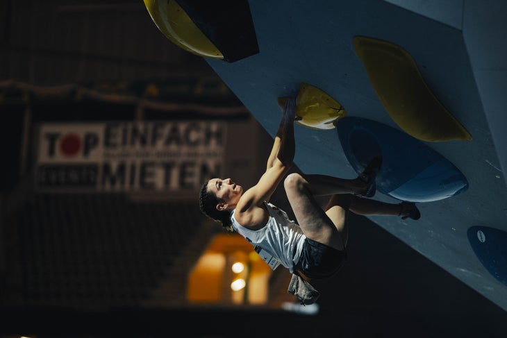 Kyra Condie bouldering on a steep wall in a competition