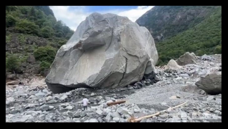 A gigantic boulder deposited in the rubble left by a landslide.