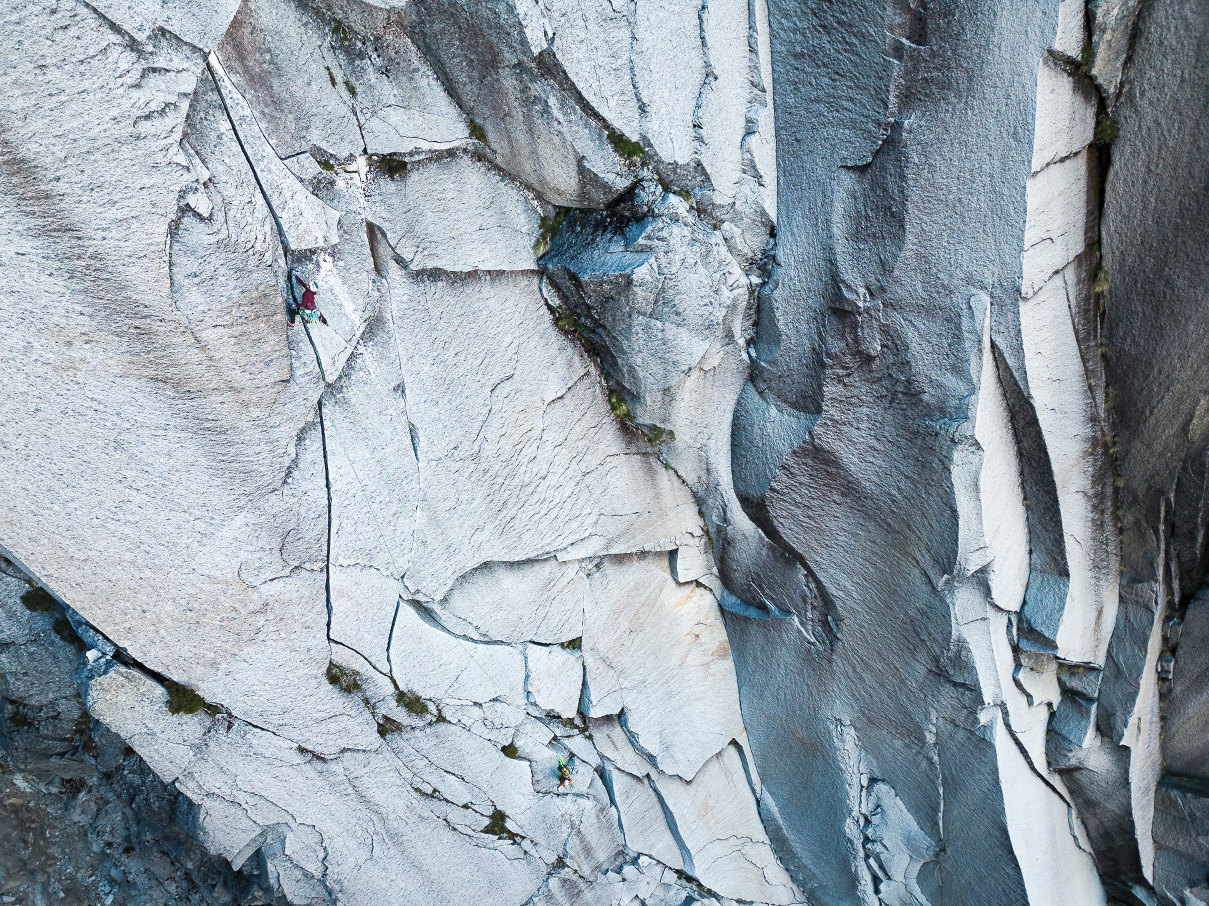 Woman climbs fractured rock on a big wall in Chile.