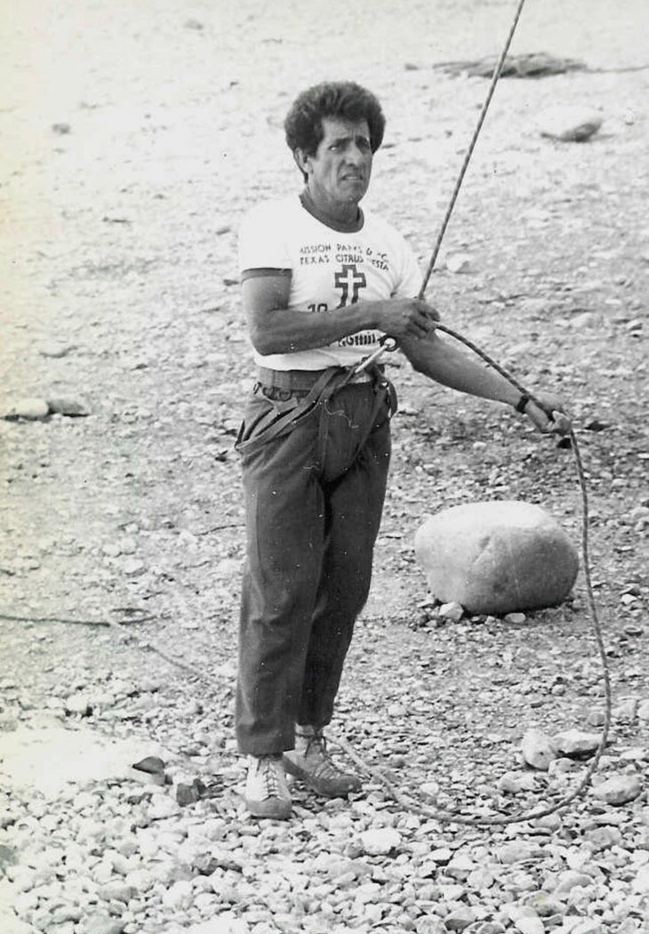 Juan de Dios de Leon Camero, a youth climbing instructor, top rope belays outdoors.