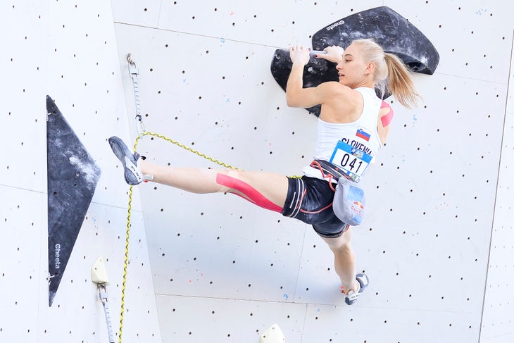 Janja Garnbret wearing a pair of Five Ten Hiangles while leading a route in a competition.