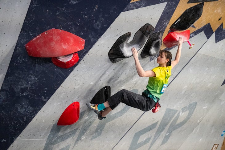 A female Olympian wearing a pair of Scarpa Dragos during a World Cup climbing competition.