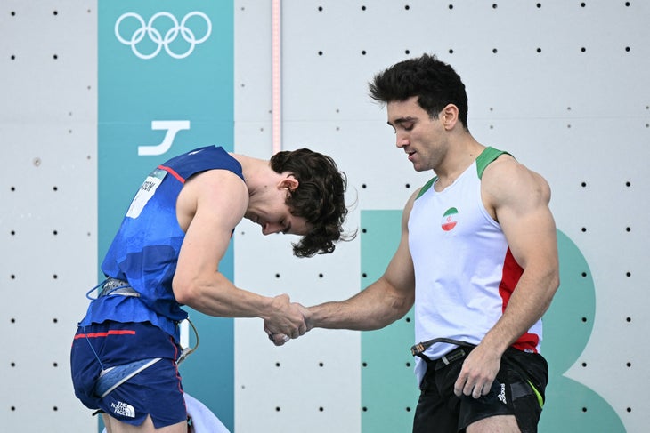 Sam Watson bowing to Reza Alipour Shenazandifard while shaking his hand.