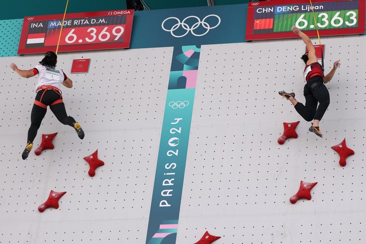 Two athletes hitting the buzzers at the end of a very close Olympic speed race.