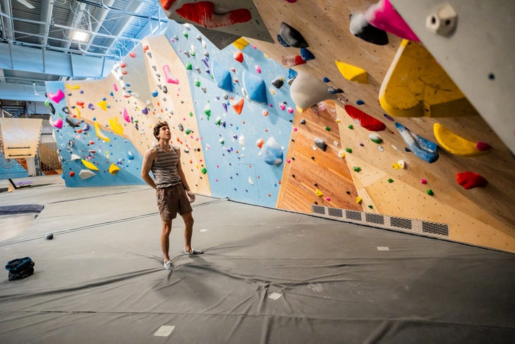 Jesse Grupper eying a boulder problem intensely during a training session at his gym.