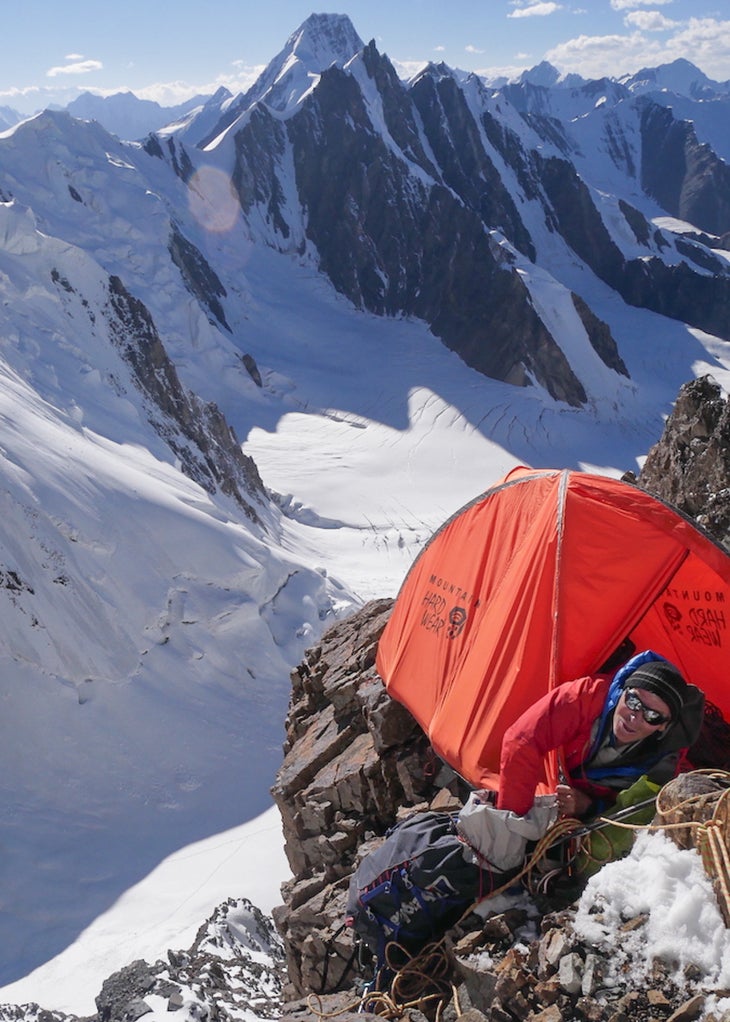 Setting up a tent on a sunny day, high on an unclimbed mountain in Pakistan.