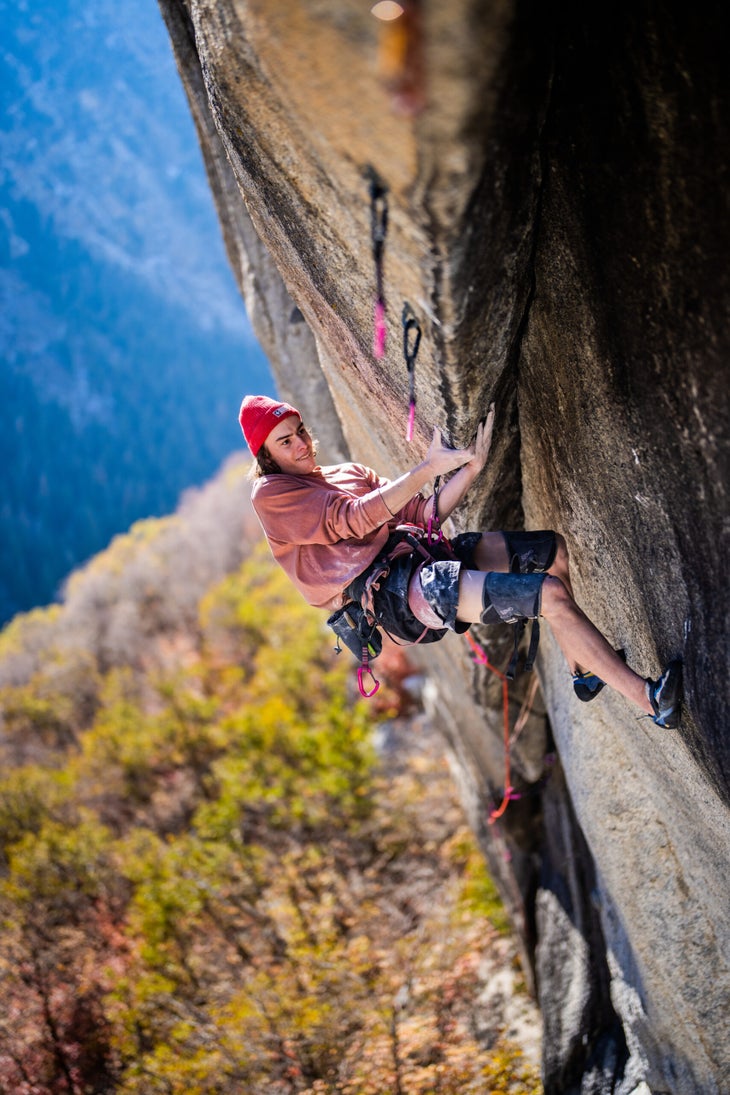 Tanner Bauer wearing a pink hat and red shirt climbing underclinging through a powerful sequence on the upper section of "Slayer," a 5.13d in Little Cottonwood Canyon, Utah.