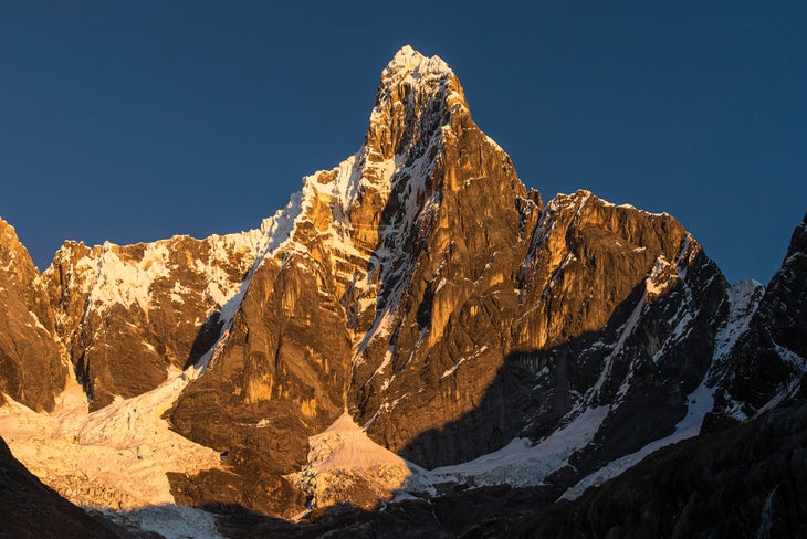 The East Face of Jirishanca at sunrise from basecamp. Reino Hongo begins on the glacial tongue on the left and climbs to the left-hand skyline before breaching the upper headwall. 