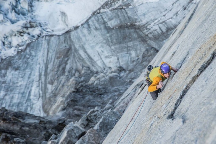 Pete Whittaker climbs a vertical, sheer pane of granite above a glacier in Greenland.