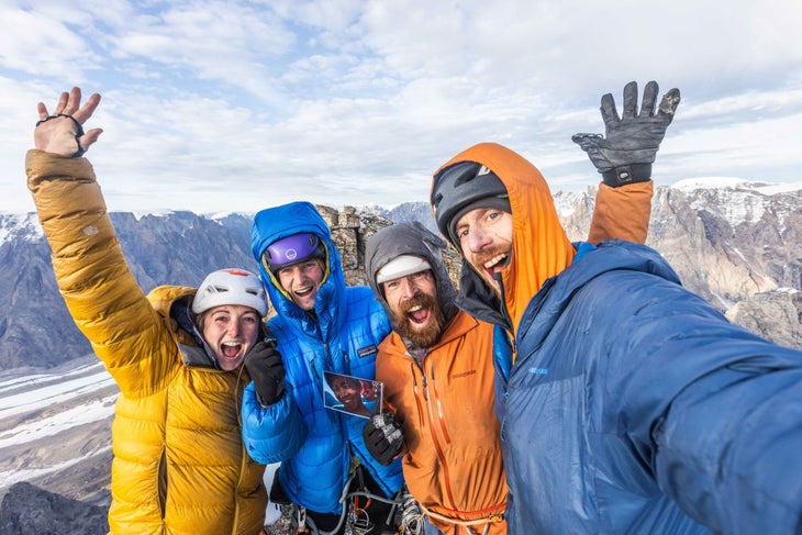 Four climbers smile on top of the summit of Greenland's Mirror Wall.
