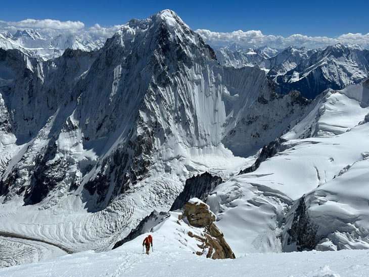 An image of a man climbing a snow slope on a 6000-meter peak in Pakistan.