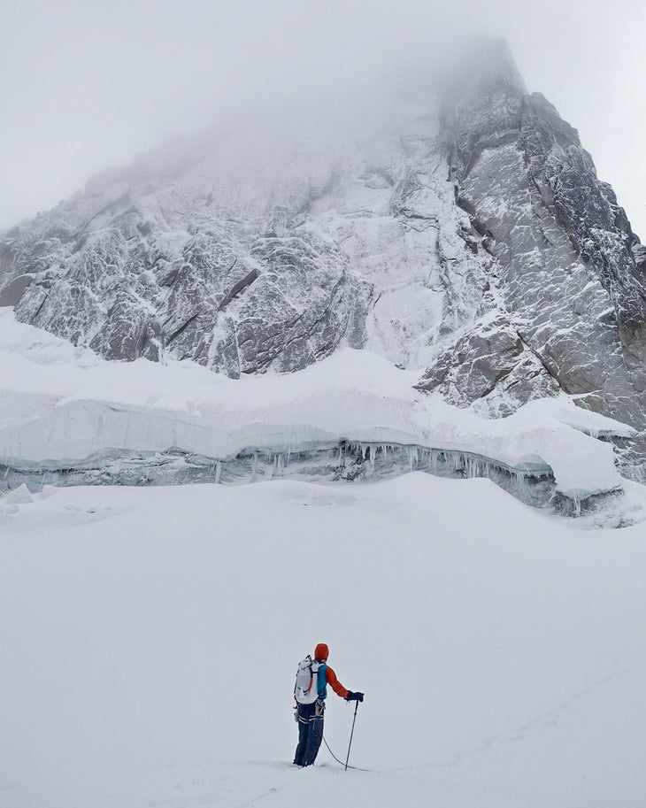 Male gear reviewer peers up at the East Face of the South Howser Spire, Bugaboos, wearing the new Alpha SL backpack as part of this review.