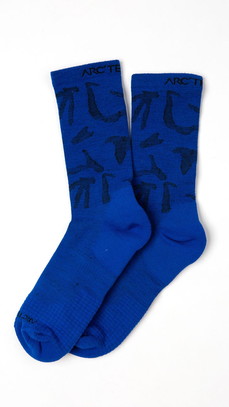 Blue Arc'teryx socks on white background. This is one of the best climbing gifts of 2024.