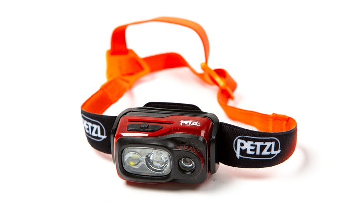 Red and black Petzl Swift RL headlamp on white background. This headlamp is one of the best climbing gifts of 2024.