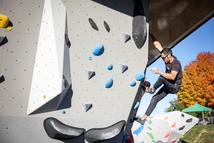 A man climbing an artificial boulder at the Boyce Boulder Park.